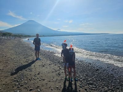 Kinderen met snorkels op het strand van Amed met uitzicht op de Mount Agung tijdens een vakantie op Bali met kinderen