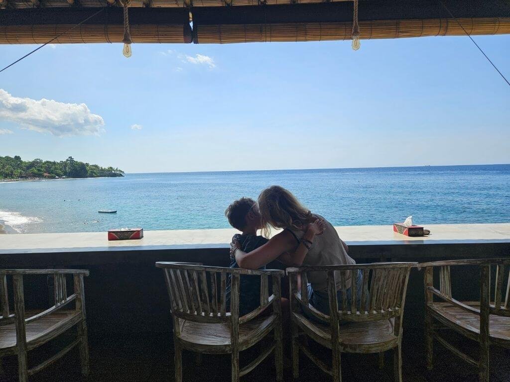 Moeder en kind in strandrestaurant met uitzicht op zee in Amed, Bali met kinderen