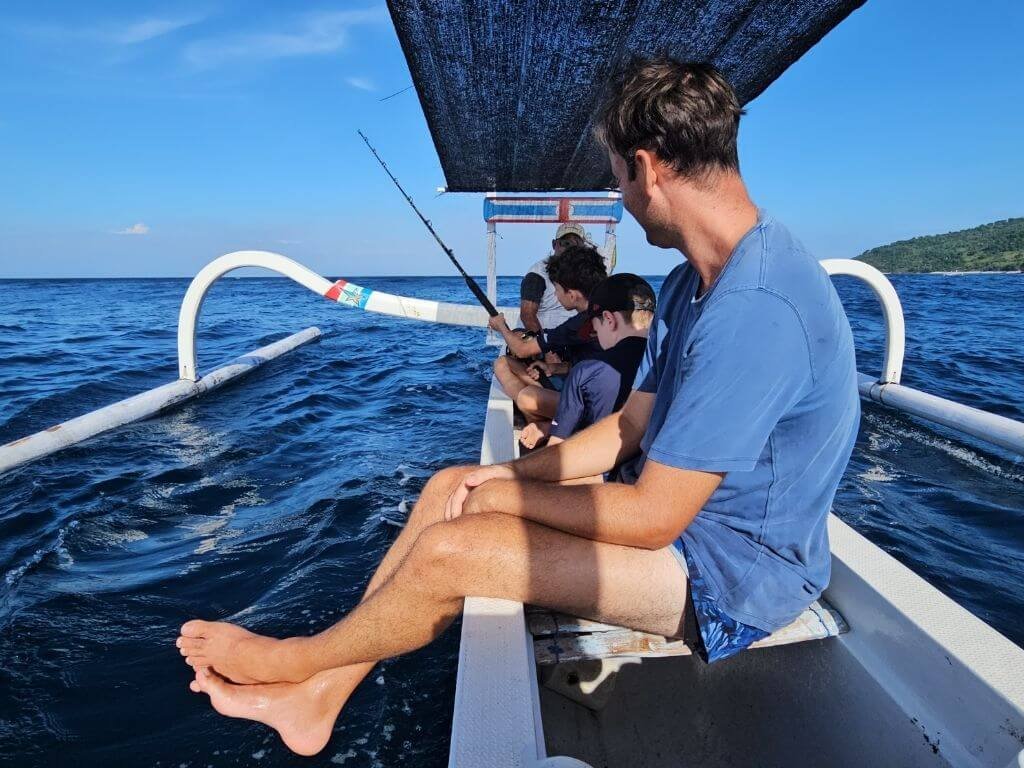 Kinderen vissen met handhengel op zee bij Amed, Bali met kinderen