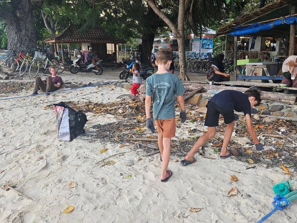 Kinderen helpen mee met beach clean-up op Gili Air met kinderen aan het strand