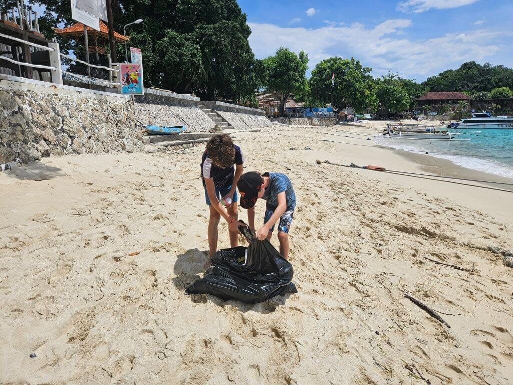 Kinderen ruimen aangespoeld afval op het strand op Nusa Lembongan – Nusa Lembongan met kinderen