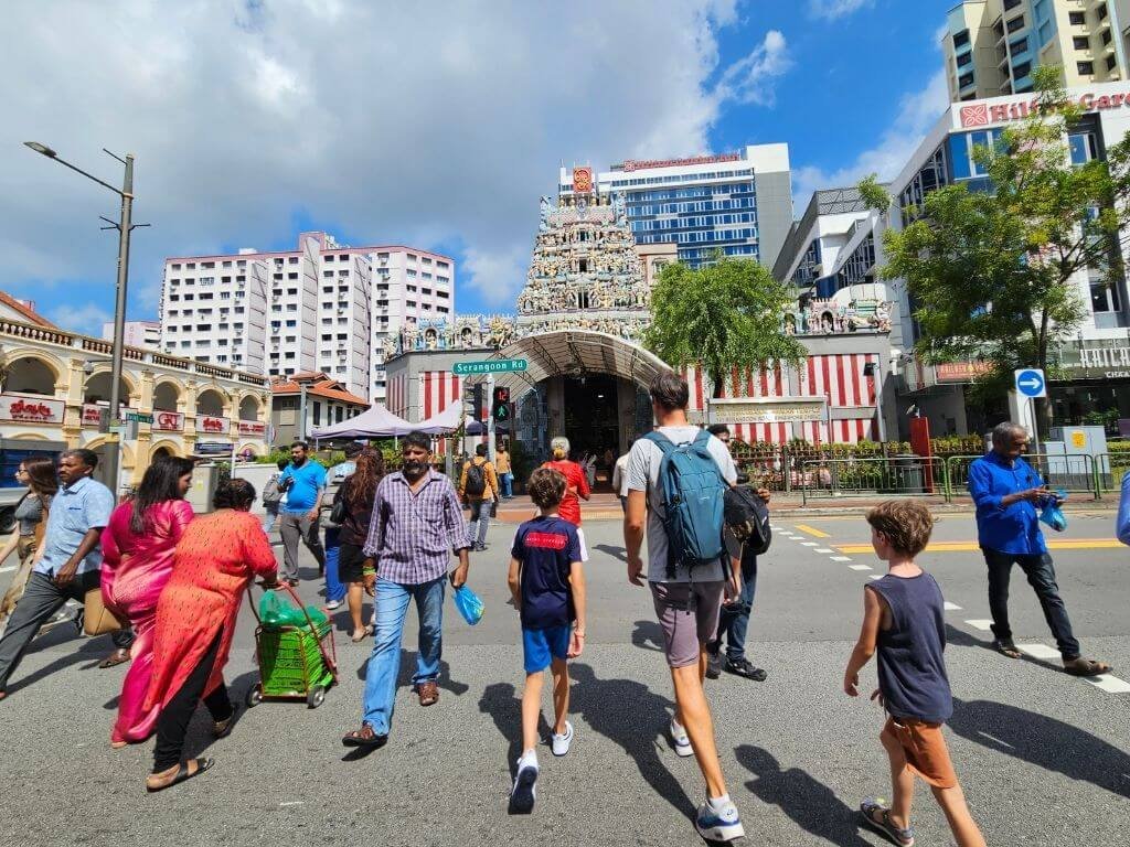 Tempelbezoek in Singapore met kinderen Kinderen wandelen voor de kleurrijke Sri Srinivasa Perumal Tempel in Singapore – een unieke ervaring tijdens onze reis met kinderen.