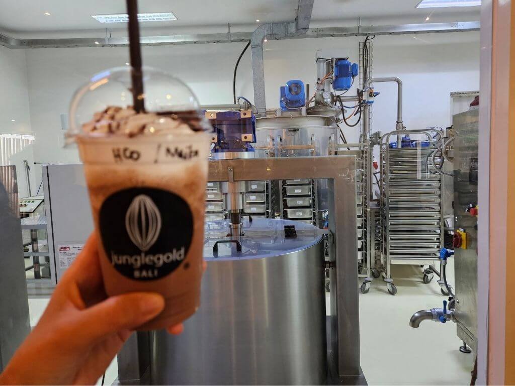Pauze bij Junglegold: chocolade met uitzicht Verse chocoladedrank in de hand met uitzicht op de Junglegold Chocolate Factory – heerlijke pauze onderweg van Lovina naar Canggu met kinderen