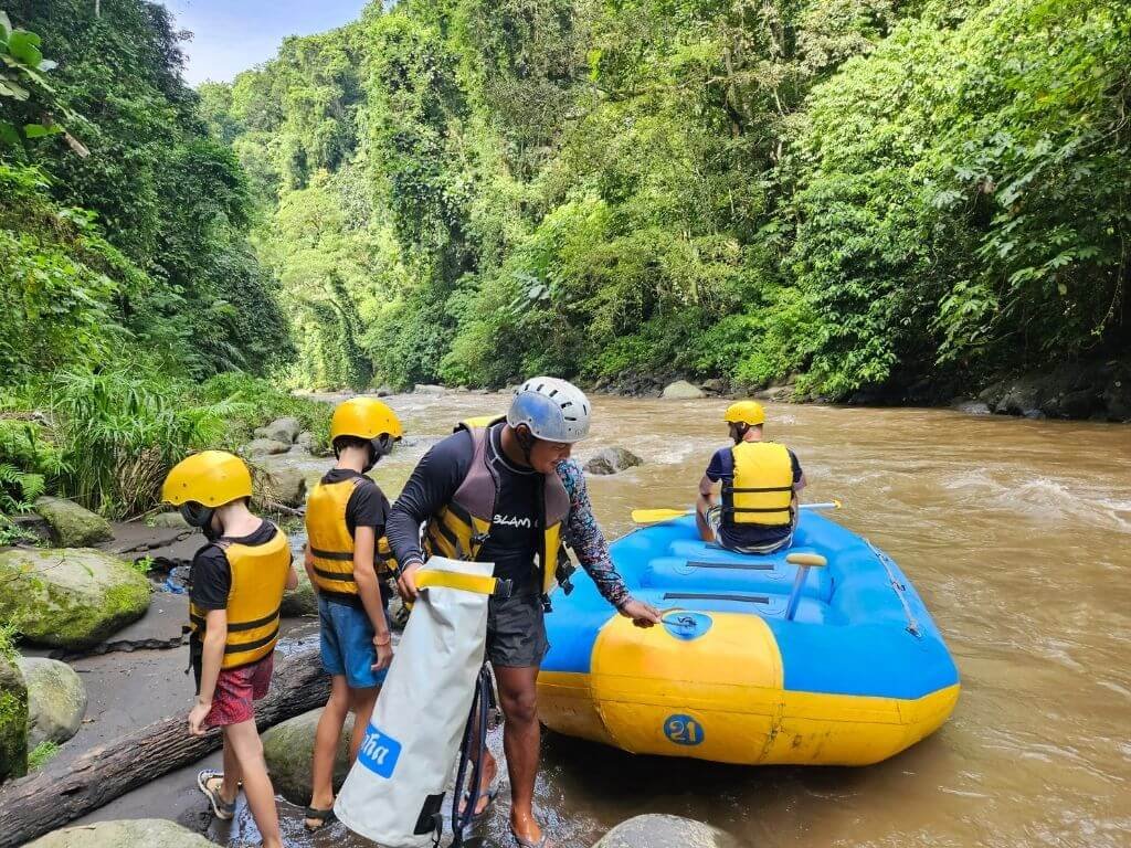 Ubud met kinderen – kinderen stappen in de raftboot, omringd door tropisch groen