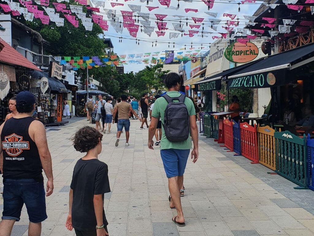 Gezin wandelt over de levendige Quinta Avenida in Playa del Carmen tijdens een gezinsvakantie in Mexico met kinderen