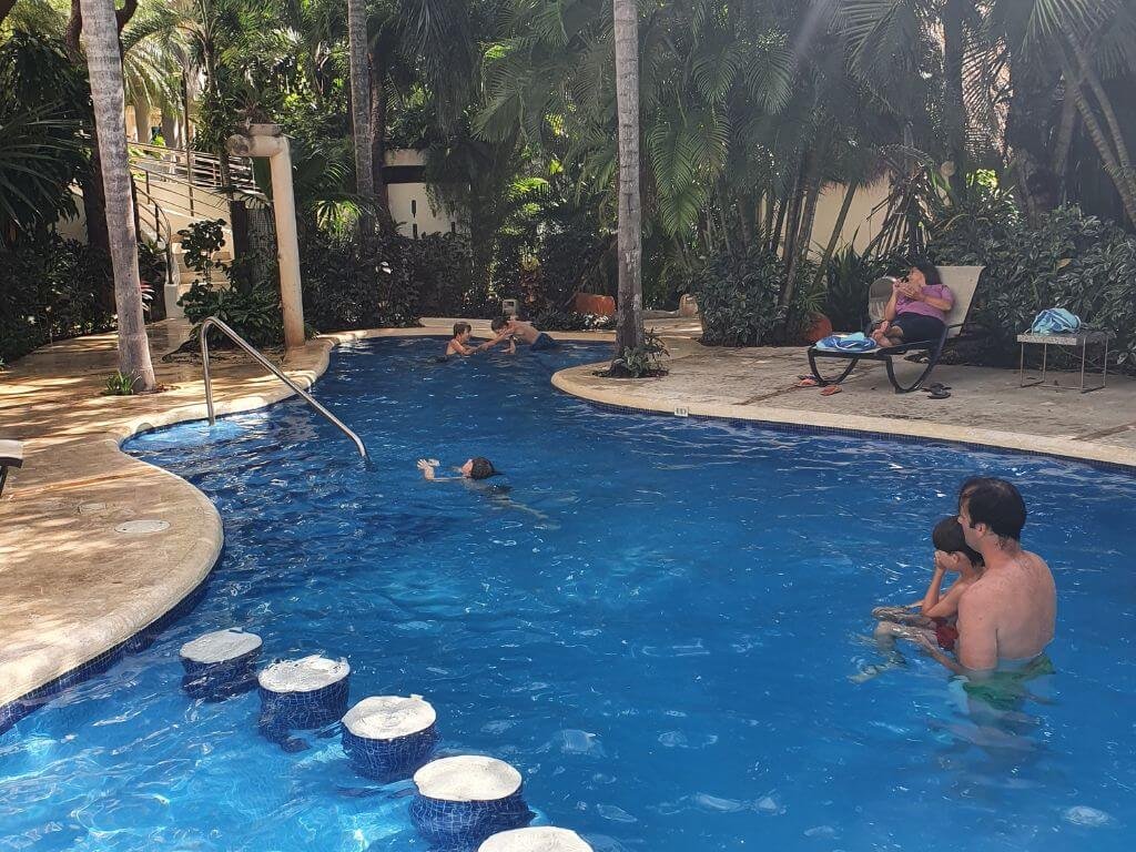 Zwembad omgeven door tropische tuin bij Riviera Maya Suites in Playa del Carmen tijdens een gezinsvakantie in Mexico met kinderen