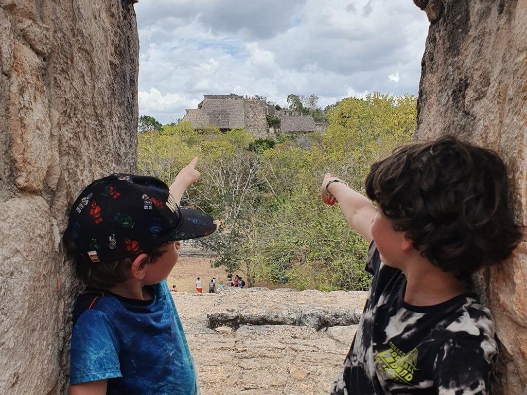 Kinderen wijzen naar de indrukwekkende tempel van Ek Balam tijdens een gezinsreis in Mexico met kinderen